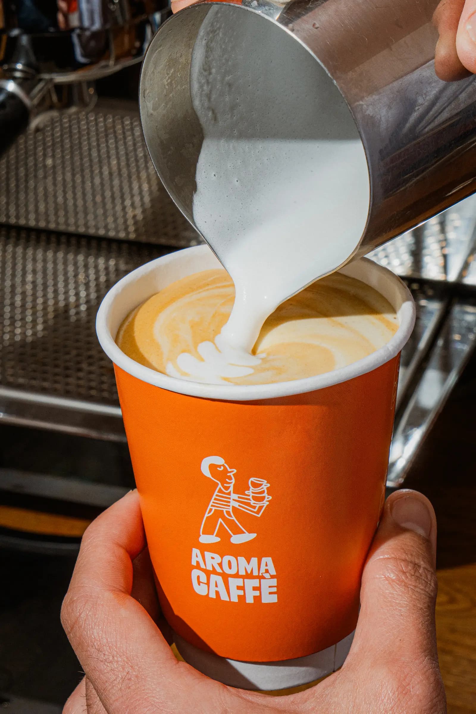 Latte art versé dans un gobelet Aroma Caffè, Paris 14e