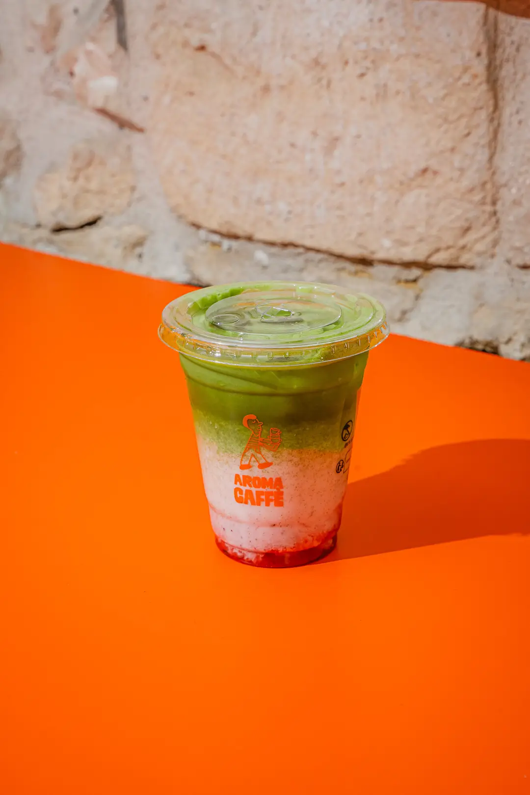 Matcha latte au dégradé vert, blanc et rouge dans un gobelet Aroma Caffè, Paris 14e